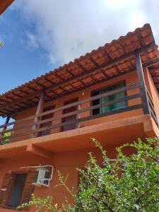 an orange apartment building with a balcony at Pousada Mangaba da Serra in Serra do Cipo