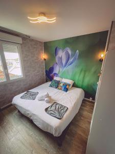 una camera da letto con un letto e un dipinto sul muro di Van Gogh gare By Carl-Emilie a Épinal
