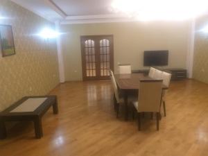 uma sala de jantar com uma mesa e cadeiras e uma televisão em Apartament caspian plaza em Baku