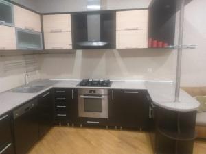 uma cozinha com armários a preto e branco e um fogão em Apartament caspian plaza em Baku