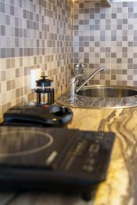 a sink and a microwave in a kitchen at Marousi Suites in Perissa