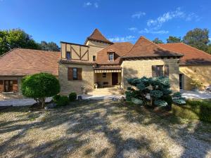 een groot bakstenen huis met een tuin bij Villa & Spa dans le Périgord in Proissans