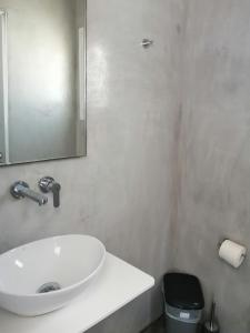 een badkamer met een witte wastafel en een spiegel bij Paraga View in Paraga