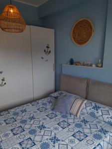 um quarto com uma cama com uma colcha azul e branca em IL VELIERO em Scilla