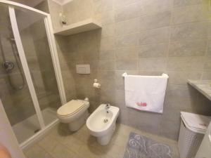 uma casa de banho com um WC, um chuveiro e um lavatório. em IL VELIERO em Scilla