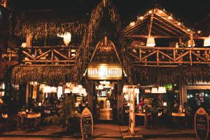 a restaurant with people sitting at tables in a building at Tiki Limbo in Montañita +40 photos