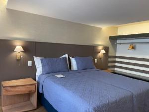1 dormitorio con cama azul y edredón azul en Pousada Do Largo, en Tiradentes