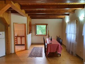 a dining room with a table and a kitchen at Livada lui Papu in Izvoarele