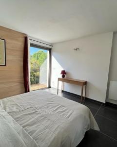 a bedroom with a large bed and a window at Le Cube des Garrigues in Vallérargues