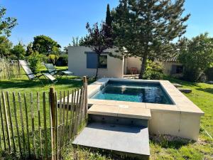 a swimming pool in a yard with a fence at Le Cube des Garrigues in Vallérargues