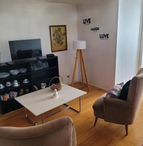 sala de estar con mesa, 2 sillas y TV en Un espacio cálido ideal para desconectar. en Buenos Aires