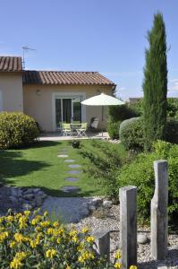 a garden with a patio and an umbrella at Martichris in Châteauneuf-de-Gadagne