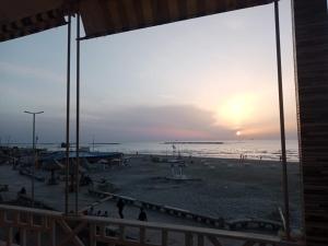 uma vista para uma praia ao pôr-do-sol com pessoas nela em Villa 32 - Marouf Group em Ras El Bar