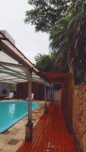 una piscina con terraza de madera junto a una casa en Apartamento Guarapuvu, en Florianópolis