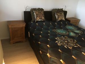 a bedroom with a black bed with pillows at Glamping aan de Thoolse kust in Poortvliet