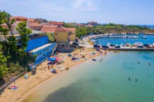 una playa con un grupo de personas en el agua en Melanie en Privlaka