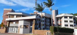 un edificio con una palmera delante en Apartamento Guarapuvu, en Florianópolis