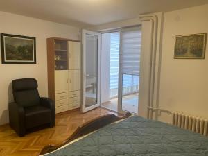 1 dormitorio con 1 cama, 1 silla y 1 ventana en Sandra, en Niš