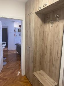 ein Badezimmer mit einem Holzschrank und einer Dusche in der Unterkunft Sandra in Niš