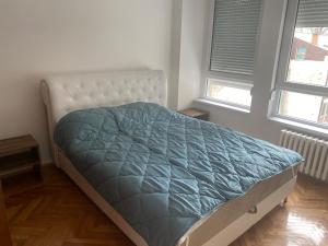 Sandra في نيشْ: سرير مع لحاف أزرق في غرفة النوم