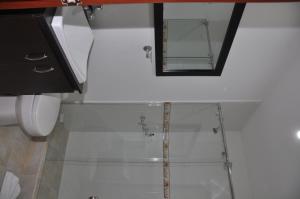 a bathroom with a mirror and a toilet at Apartamentos Plaza Modelia in Bogotá