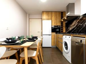 a kitchen with a table and chairs and a washer and dryer at Mundaka Sea & Mountain Views. Wifi, Parking in Mundaka