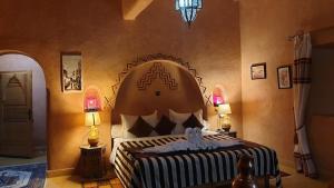 a large teddy bear sitting on top of a bed at Riad Paradise of Silence in Aït Benhaddou