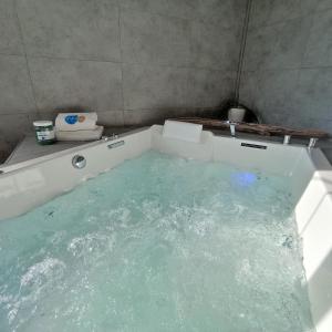 a bath tub filled with water in a bathroom at Hôtel de charme & SPA Le Grand Large in La Bernerie-en-Retz +57 photos
