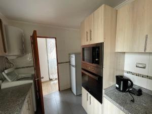 a kitchen with a microwave oven and a refrigerator at Edificio don Tomas 3D in Antofagasta