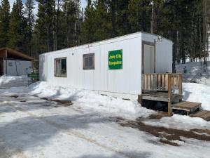 a white building with a sign on it in the snow at Jade City Bungalow in Jade City