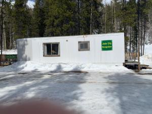 a white building with a sign on it in the snow at Jade City Bungalow in Jade City