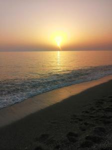 a sunset on a beach with the ocean at Residence Mareblu in Nocera Terinese