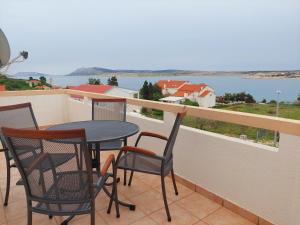 a balcony with a table and chairs and a view of the water at Apartments Donadic I, Caska in Novalja