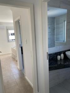 uma casa de banho branca com um lavatório e um espelho em DEPARTAMENTO NUEVO CENTRICO 2 DORMITORIOS 2 Baños COCHERA-PISCINA em Santa Fé