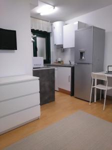kuchnia z białymi szafkami i stołem oraz tableablish w obiekcie Estudio. Sada, A Coruña. w mieście Sada