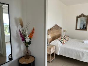 - une chambre avec un lit et un vase de fleurs dans l'établissement Residence Castugna, à Cargèse