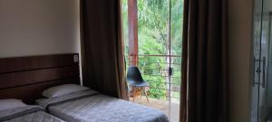 a bedroom with a bed and a large window at Hotel Serra do Gandarela in Rio Acima