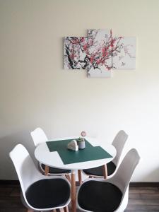 a table and chairs in a room with three paintings at Wisienka in Duszniki Zdrój