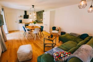 a living room with a green couch and a table at Rieslingresidenz in Traben-Trarbach