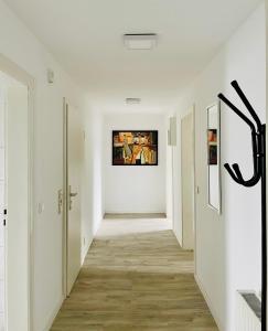 an empty hallway with white walls and wood floors at FeWo with six Beds an six Guests in Hagen