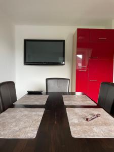 a conference room with a table with chairs and a flat screen tv at FeWo with six Beds an six Guests in Hagen +7 photos