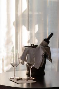 Una botella de vino y dos copas en una mesa. en Hotel Grand María en Morelia