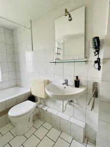 ein weißes Bad mit einem WC und einem Waschbecken in der Unterkunft FeWo with six Beds an six Guests in Hagen