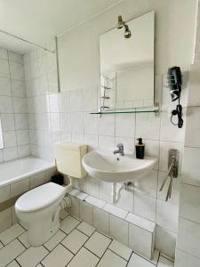 a white bathroom with a toilet and a sink at FeWo with six Beds an six Guests in Hagen
