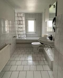 ein weißes Bad mit einem WC und einem Waschbecken in der Unterkunft FeWo with six Beds an six Guests in Hagen