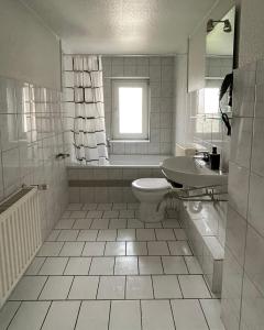 a white bathroom with a toilet and a sink at FeWo with six Beds an six Guests in Hagen