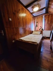 una camera con un letto su una parete in legno di RUSTIC Vidra a Vidra