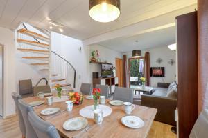 une salle à manger avec une table, des chaises et un escalier dans l'établissement Seepark Kirchheim Ferienhaus bei Diane mit Sauna, à Kirchheim
