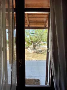 an open glass door with a view of a yard at Serenita Villa II in Zakynthos Town