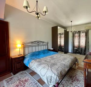 a bedroom with a bed and a chandelier at Serenita Villa II in Zakynthos Town